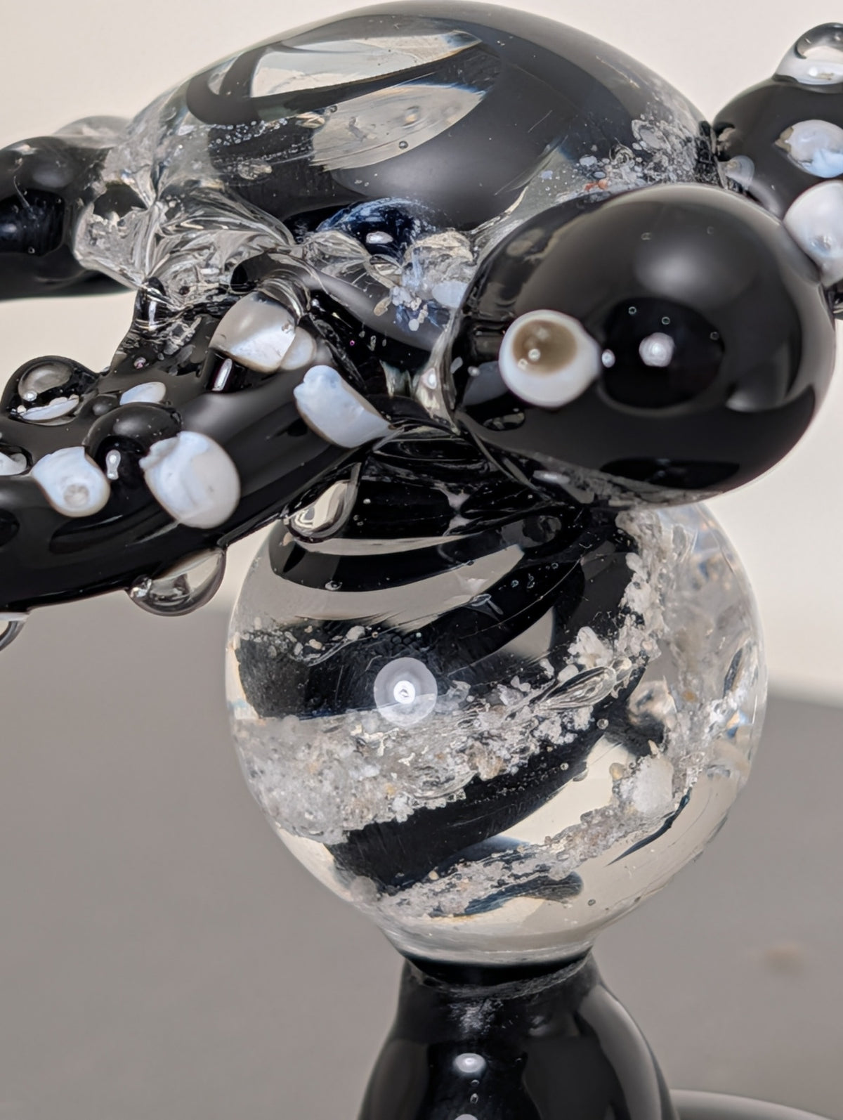 Close-up of cremation ash suspended in the clear memorial marble stem of a black turtle Legacy Goblet